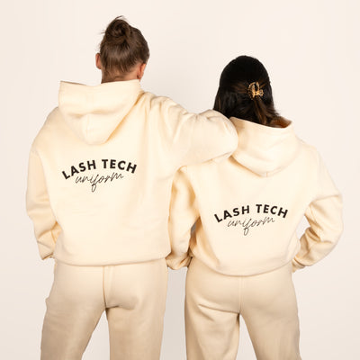 Two models wearing cream lash technician embroidered tracksuits