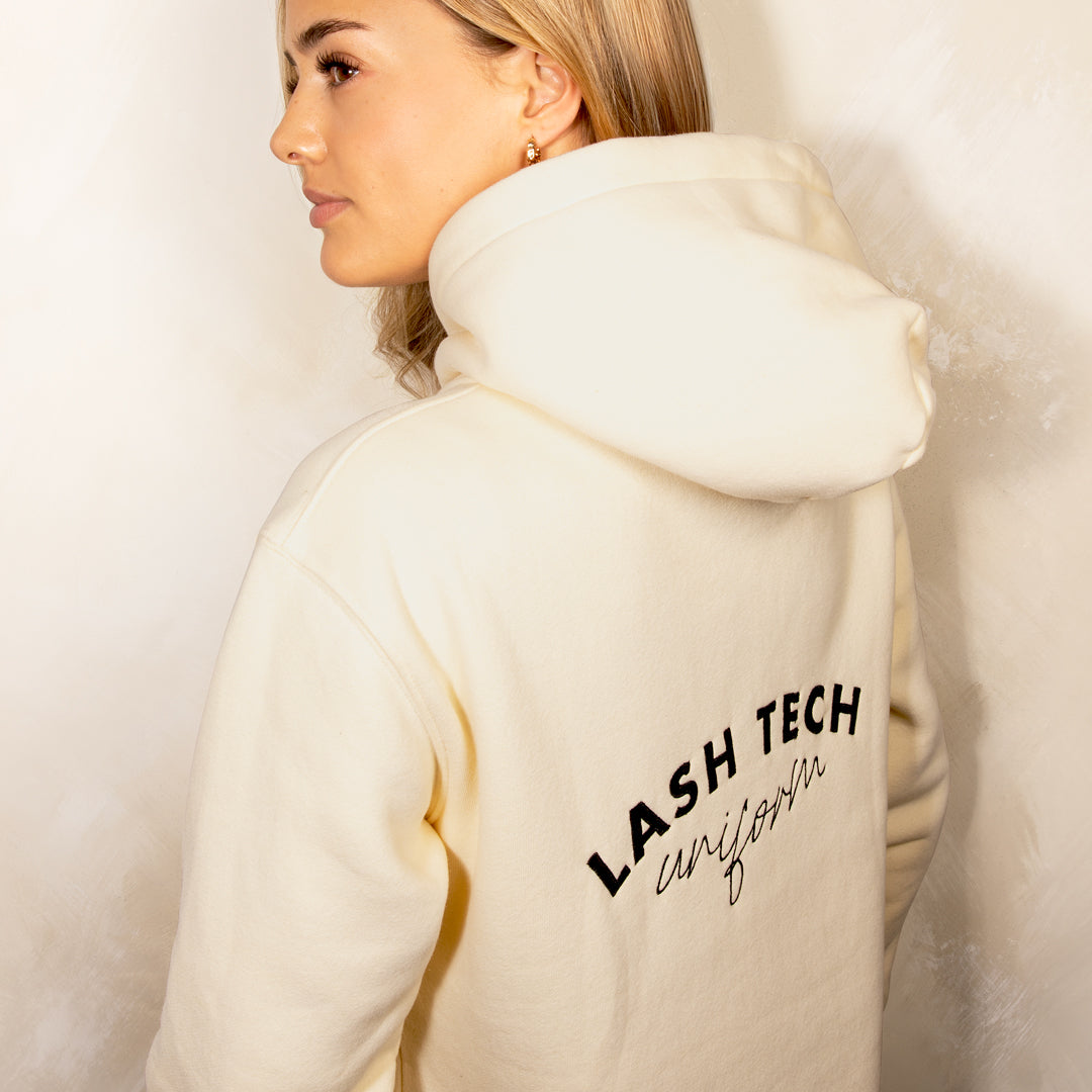 Cream hoodie with "Lash Tech Uniform" embroidered on the back